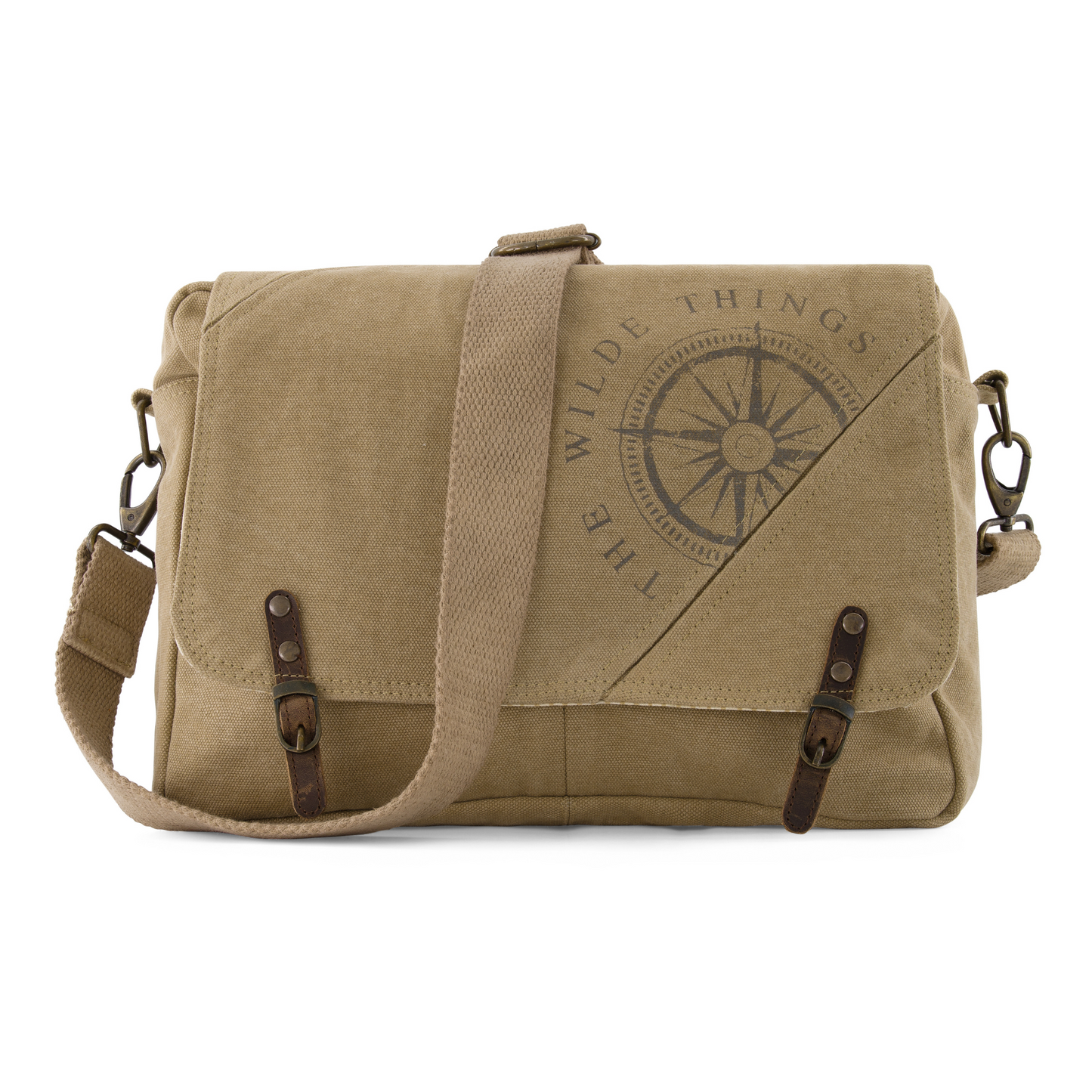 a canvas crossbody satchel with strap drapped over the front, showing compass logo screen printed on the front, leather tabs, and brass hardware attaching the adjustable strap to the sides of the satchel
