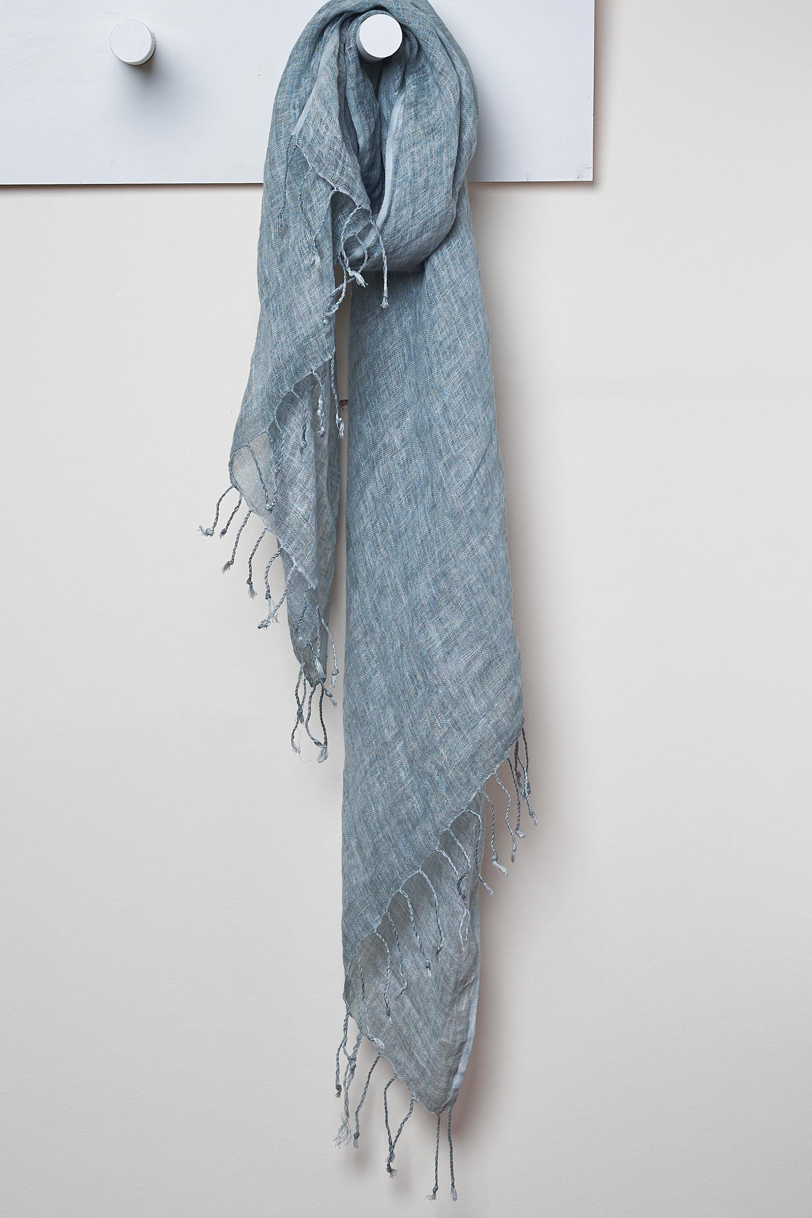 3 Visits To Cairo pure linen scarf in Titanium.  looped around a hook detailing the linen texture and thin tassels tied at the short edges of the scarf.
