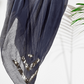 Grey cotton scarf with sequin details draped over a wooden rod on a white background.