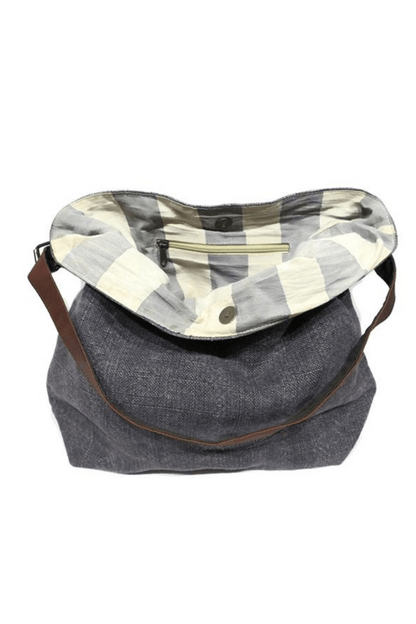 Charcoal grey sustainable jute shoukder bag folded open so the striped lining is showing