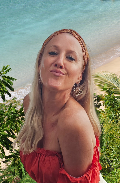 A model with long blonde hair is wearing a silk headband in autumn tones of russet and gold.