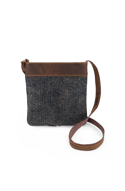 Smoky black, Graphite coloured mini crossbody bag made from sustainable jute and soft leather trim against a white background, with long adjustable strap curled around the bag