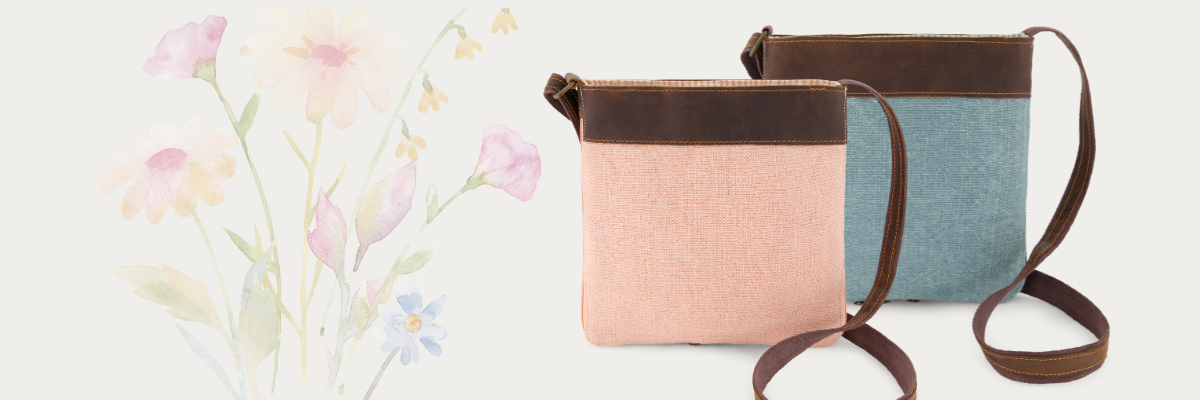 Two crossbody bags, one peony pink and one chambray blue, with a floral design on a light background.