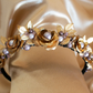A narrow black velvet covered headband featuring vintage golden brass roses and leaves amongst mixed shades of lavender Swarovski pearls 