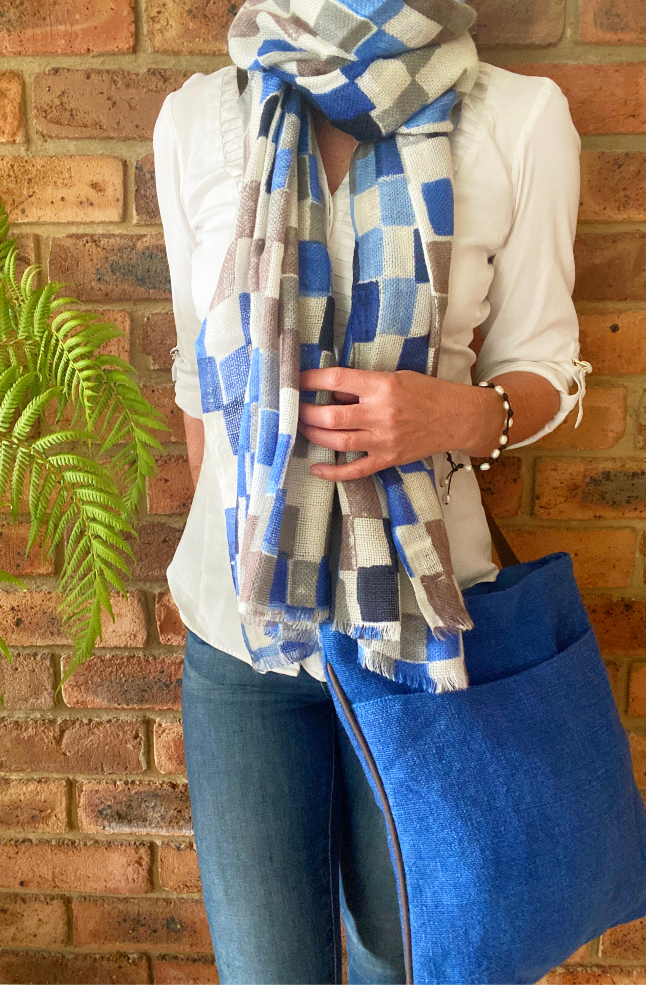 The Cobalt variant of the hold me close cross body bag on a woman's shoulder. 
