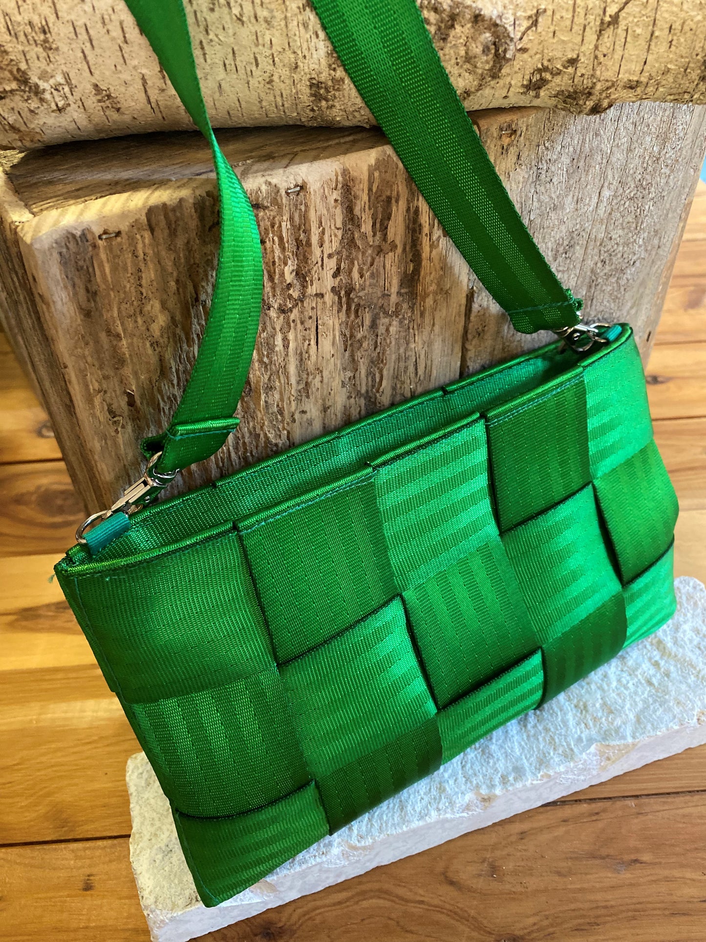 Upcycled car seat belt bag in emerald green. A rich green criss cross pattern with seatbelt texture, and a long over the shoulder style strap.