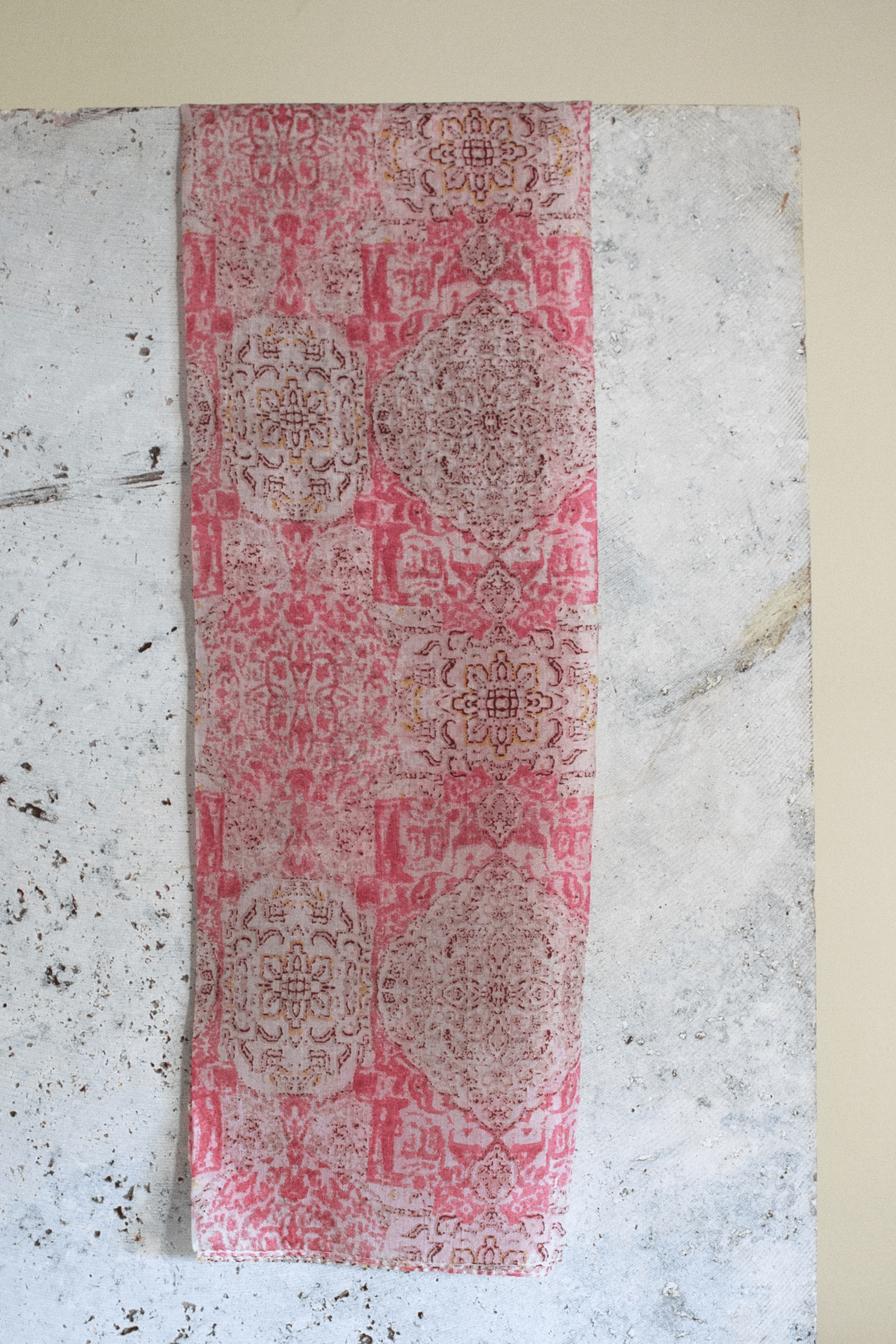 the rosewater scarf hanging on a slab of marble emphasising the deep pink tones