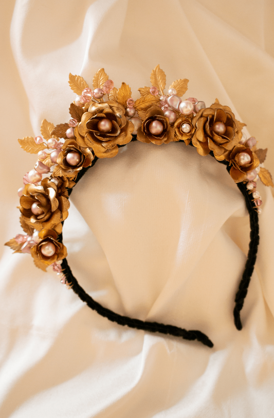 A black, velvet covered, narrow headband with a large arrangement of vintage brass flowers, leaves, Swarosvki pearls and crystals in shades of delicate, soft pinks. Handmade in Melbourne