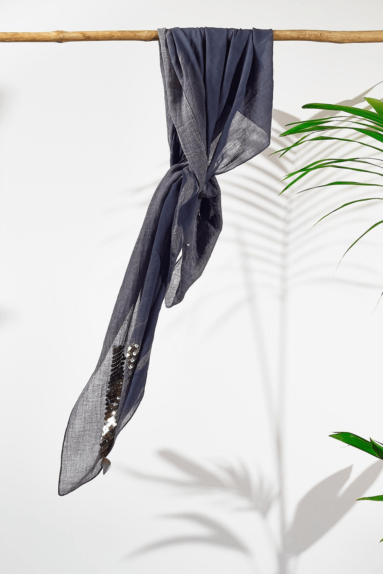 The scarf is loosely tied around a rod showing how the fabric falls.
